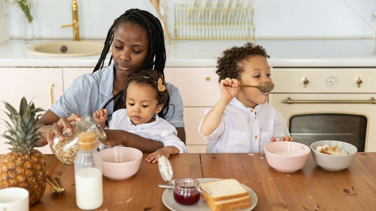 Mother with two small children in a cozy kitchen setting preparing a meal together—highlighting family engagement during mealtime and feeding routines.