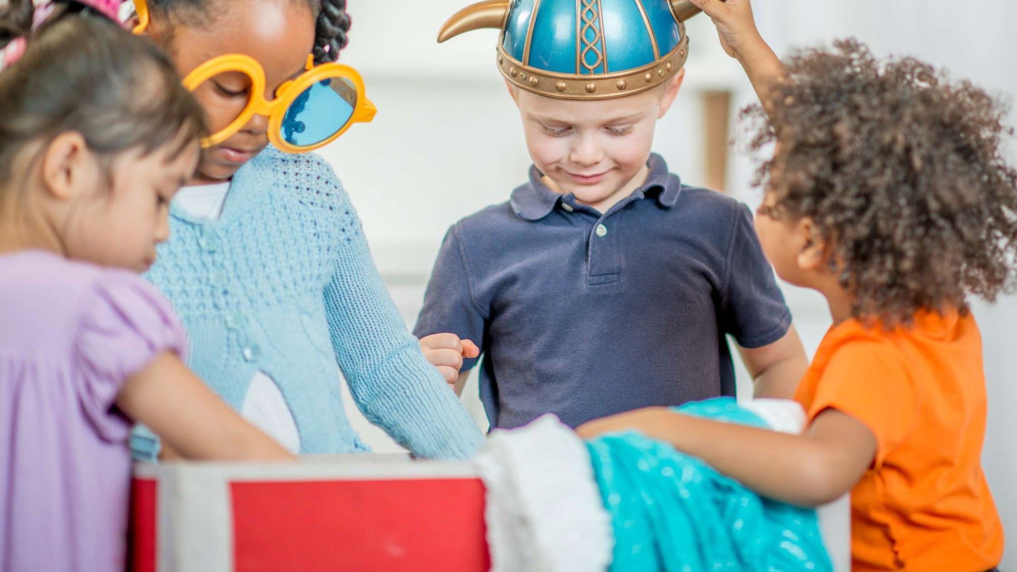 Child playing with dress up clothes—ideal preoperational stage toys